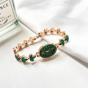 Macro detail of oval emerald green dial and rose gold gemstone bracelet watch strap