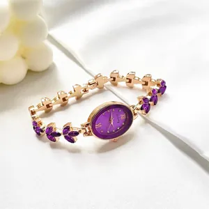 Elegant gold oval bracelet watch with purple dial and crystal markers on white silk