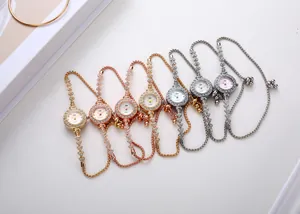 Gros plan de montres à quartz élégantes avec strass et bracelets chaînes en plusieurs tons
