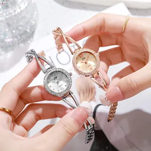 Close-up of elegant rose gold and silver quartz watches with rhinestone bezel and chain strap