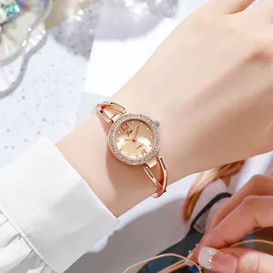 Detail of rose gold quartz watch with rhinestone bezel on a model wrist