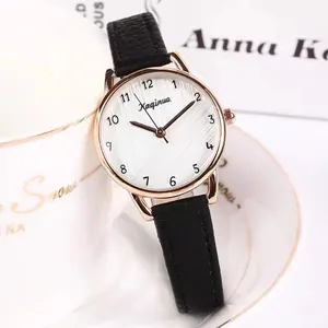 Elegant women's quartz watch with black leather strap and rose gold case by a ceramic cup