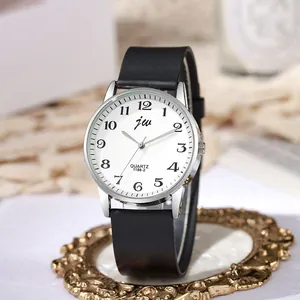 Detailed close-up of a minimalist quartz watch with black silicone strap on gold stand