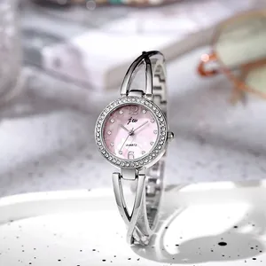 Detail of pink mother-of-pearl dial with rhinestone bezel and hollow bracelet band