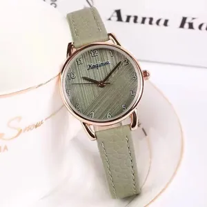 Detailed shot of a rose gold watch with green dial hung on a stylish white coffee cup