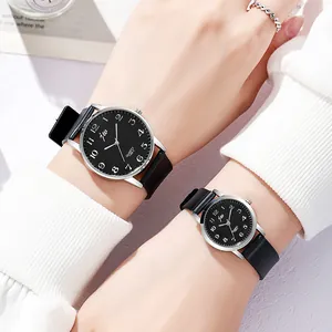 Detailed view of stylish couple's quartz watches with black leather straps and silver cases
