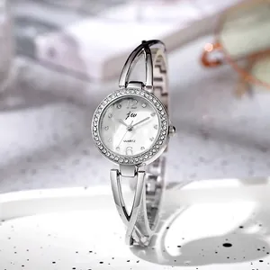 Detailed close-up of a silver ladies watch with a crystal bezel and pearl dial