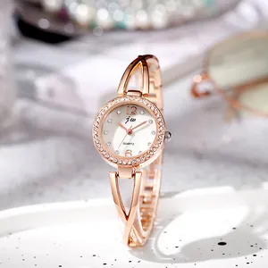 Close-up of elegant rose gold women's watch with crystal bezel and metal hollow strap