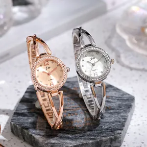 Detailed view of women's quartz watches with rhinestone bezels on marble stand
