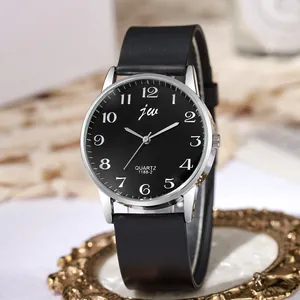 Minimalist black dial watch with silver case and matte strap on decorative tray