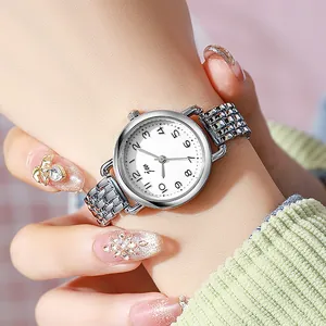 Montre femme en acier argenté avec cadran blanc et chiffres au poignet