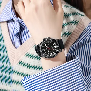 Close-up of sporty quartz watch with large black dial and luminous hands on wrist