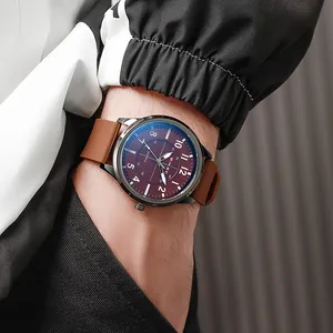 Close-up of men's quartz watch with burgundy dial and brown silicone strap on wrist