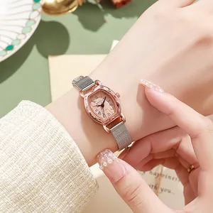 Detail of tonneau-shaped rose gold ladies watch with mesh band on a wrist