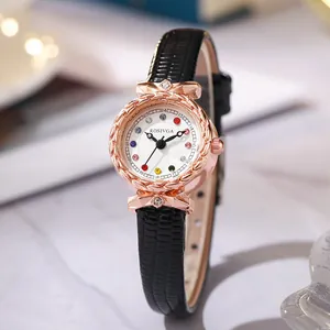 Detail of rose gold watch case with colorful rhinestone indices and black crocodile leather band