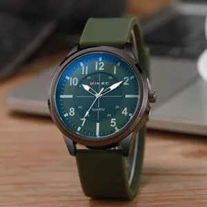 Close-up of army green military quartz watch with luminous hands on wooden table