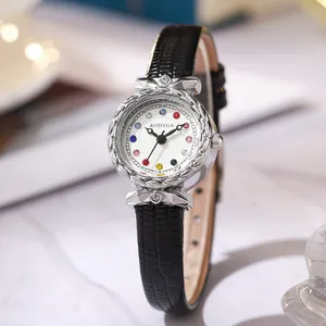 Macro shot of silver bezel with woven texture and rhinestone accents on leather watch