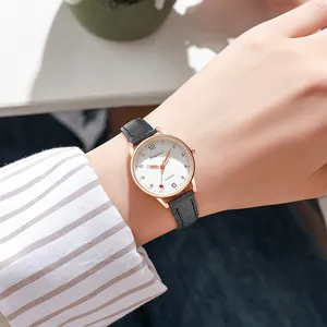 Minimalist women's quartz watch with rose gold case and black leather strap on wrist