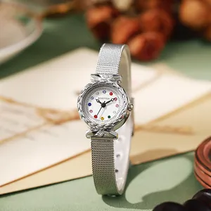 Detailed macro view of the silver mesh strap and rhinestone-encrusted round watch dial