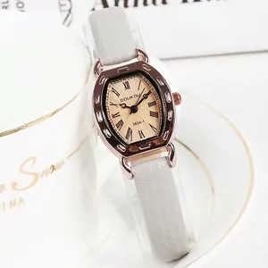 Detail van tonneau-vormig roségouden horloge met champagne wijzerplaat en grijze band