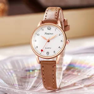 Macro detail of rose gold watch dial with red heart pointer and brown leather strap