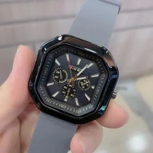 Detail of a men's sports watch featuring a black polygonal dial and grey silicone strap