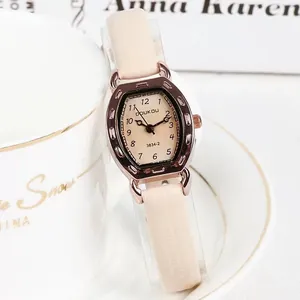 Detail van roségouden tonneau horlogekast met beige wijzerplaat en leren band