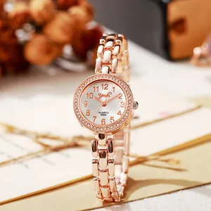 Détail de la montre femme en or rose avec lunette en strass et bracelet métallique