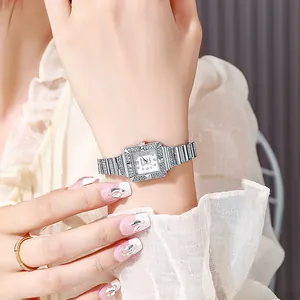 Detail of luxury silver square quartz watch with rhinestone bezel on a woman wrist