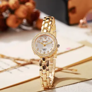 Détail du cadran de montre doré avec lunette en cristal et chiffres arabes classiques