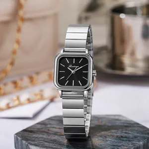 Detail of square silver watch with black dial on marble coaster for women