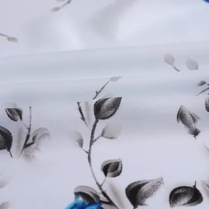Detail view of floral fabric texture showing soft draping and elegant print on a white scarf