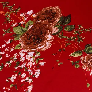 Close-up of silk scarf fabric with red rose floral pattern and smooth glossy texture