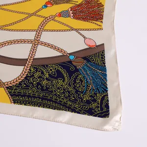 Close-up of silk scarf showing detailed rope patterns, tassels, and paisley print details