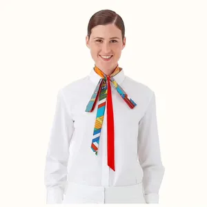 Sciarpa twilly in seta con motivi geometrici colorati annodata su un colletto bianco