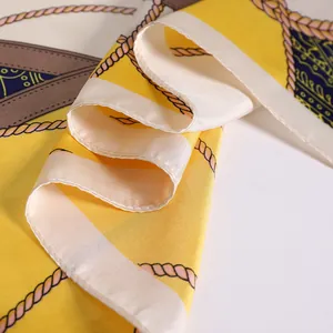 Detail of silk-like scarf featuring yellow satin fabric with nautical rope patterns