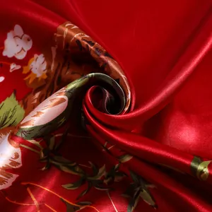 Detail of red satin scarf with vintage floral print showing silky texture and glossy finish