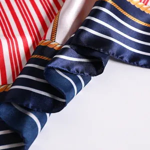 Détail macro d'un foulard en soie rayé marine avec motifs de cordes et bords roulés