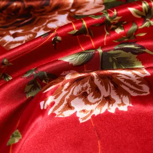 Detailed texture of red satin silk scarf with elegant blooming rose floral patterns