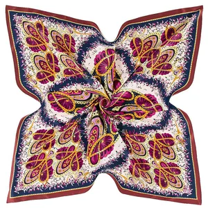 Macro view of silky twill scarf with vibrant paisley and floral patterns in magenta and gold
