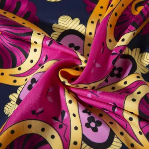 Macro shot of paisley silk-like scarf with vibrant navy blue and pink floral patterns