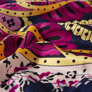 Macro view of paisley floral silk scarf fabric showing satin texture and drapes
