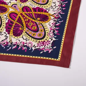 Detail shot of silk scarf showing paisley patterns and fine rolled edge stitching