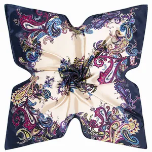 Close-up of silk-like paisley square scarf with navy blue border and vibrant colors