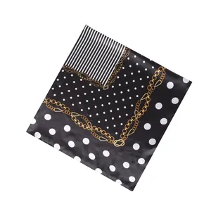 Detail view of the elegant polka dot and gold chain print on a 90x90cm square silk scarf