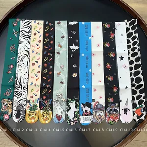 Flat lay of colorful animal print and floral satin scarves on a vintage wooden tray