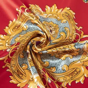 Détail macro d'un foulard en satin rouge avec motif baroque doré et texture soie