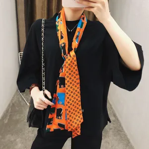 Detail van een chique oranje satijnen sjaal met geometrische en bloemige prints voor dames