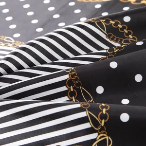 Detail of silk satin scarf showing vintage gold chain pattern and classic polka dots