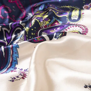 Detailed view of silk satin fabric showing elegant paisley patterns and glossy texture
